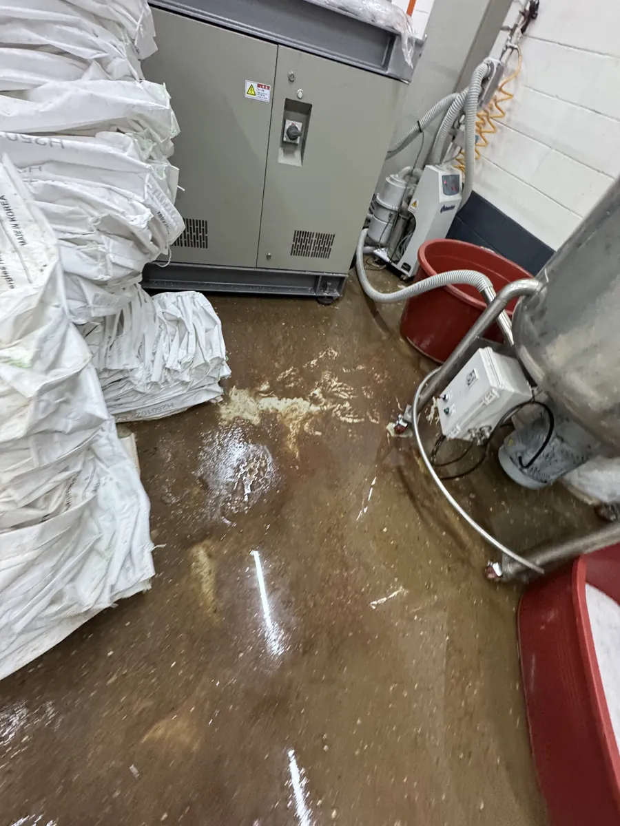 인천 남동공단 공장 침수청소 작업 전, 자재 포대 아래로 번진 오수