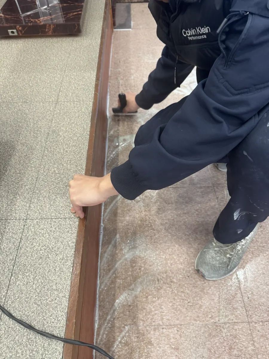용인 교회 바닥 가장자리를 손으로 박리하는 모습